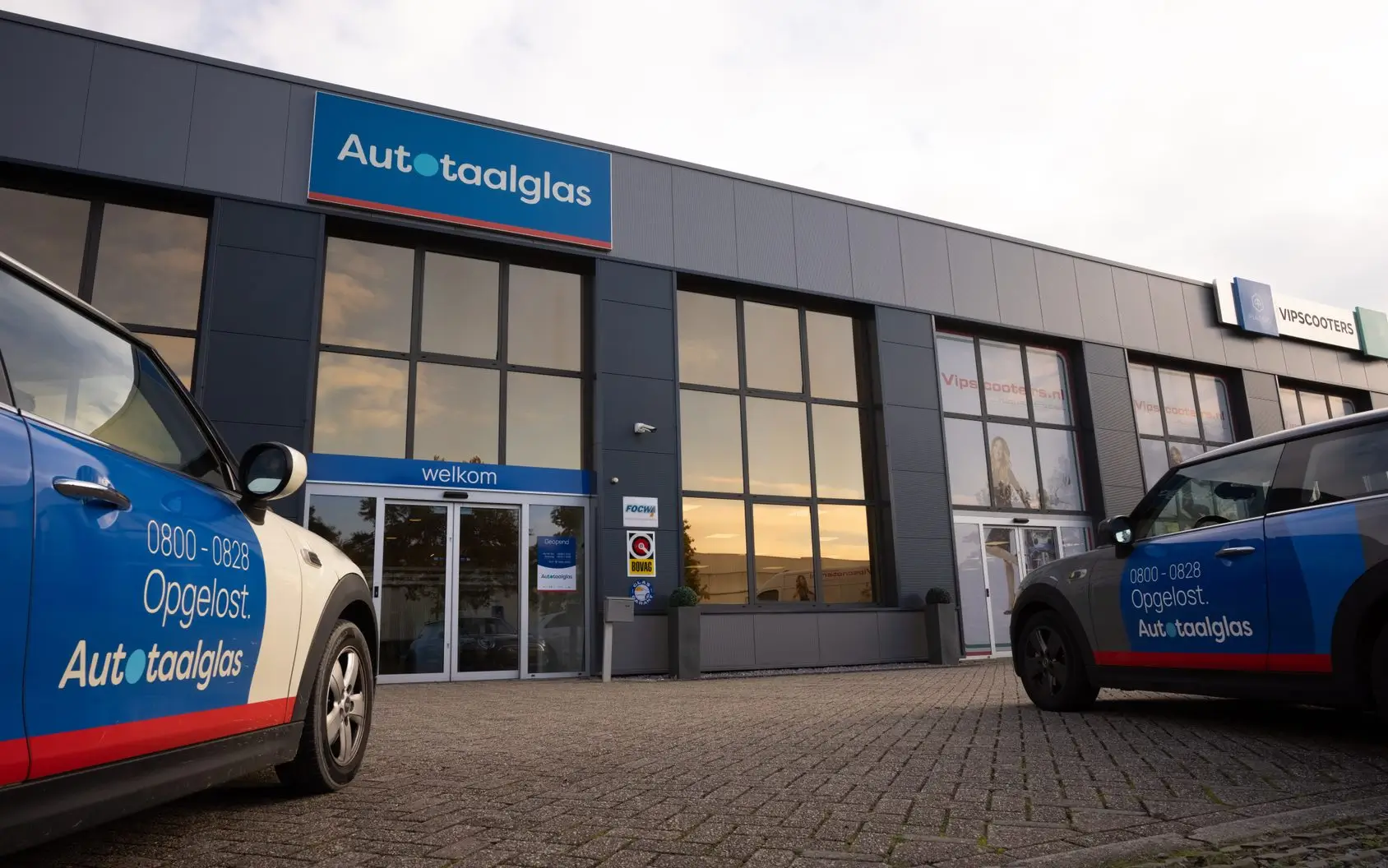 Een Autotaalglas vestiging met service-auto's, representatief voor de automotive sector waar wij de data-integratie tussen planning, service en aftersales-systemen optimaliseren.